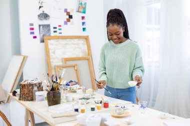 Young artist working in her painting studio