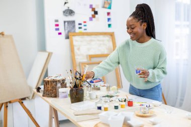 Young artist working in her painting studio