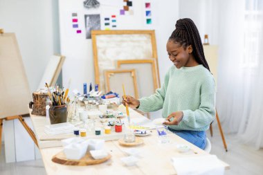Young artist working in her painting studio