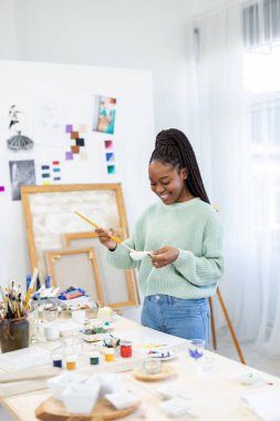Young artist working in her painting studio