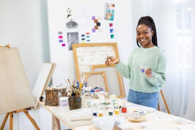 Young artist working in her painting studio