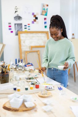Young artist working in her painting studio