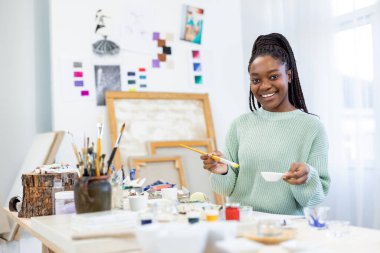 Young artist working in her painting studio