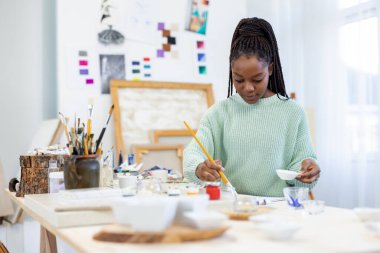 Young artist working in her painting studio