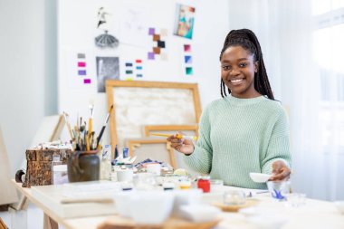 Young artist working in her painting studio