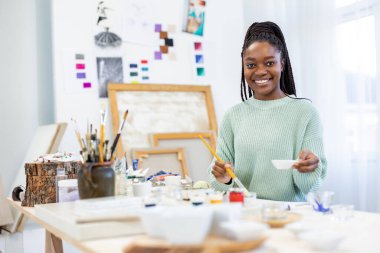 Young artist working in her painting studio