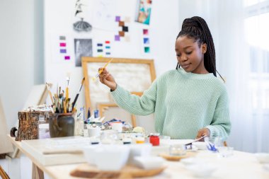 Young artist working in her painting studio