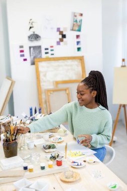 Young artist working in her painting studio