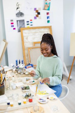Young artist working in her painting studio