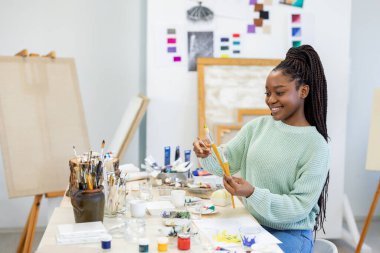 Young artist working in her painting studio
