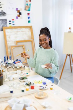 Young artist working in her painting studio