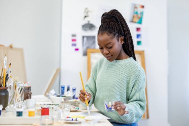 Young artist working in her painting studio