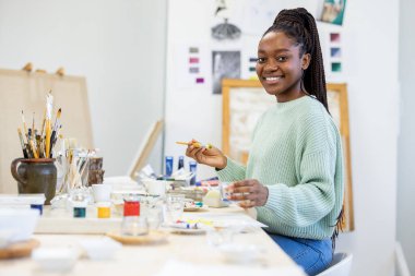 Young artist working in her painting studio