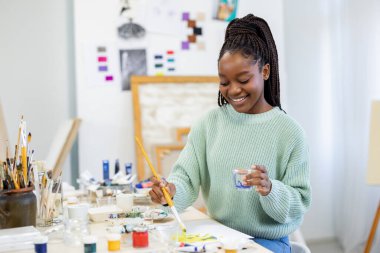 Young artist working in her painting studio