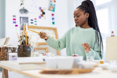 Young artist working in her painting studio