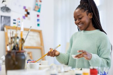 Young artist working in her painting studio
