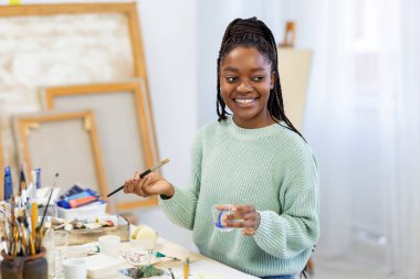 Young artist working in her painting studio
