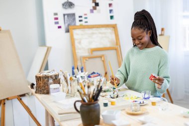 Young artist working in her painting studio