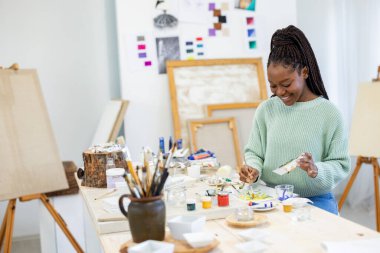 Young artist working in her painting studio