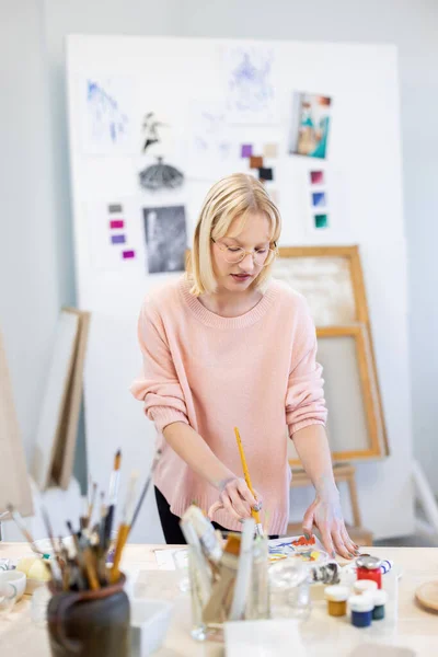 Jonge Vrouw Haar Schilderatelier Lacht Camera Voor Haar Werktafel — Stockfoto