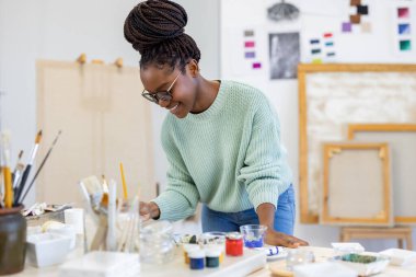 Young artist working in her painting studio
