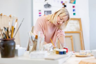 Genç kadın resim stüdyosunda.