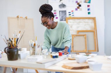 Young artist working in her painting studio