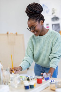 Young artist working in her painting studio