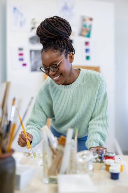 Young artist working in her painting studio