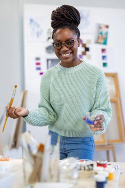 Young artist working in her painting studio