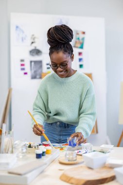 Young artist working in her painting studio