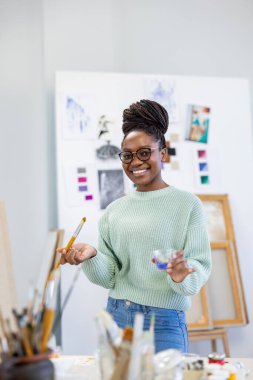 Young artist working in her painting studio