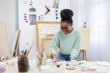 Young artist working in her painting studio