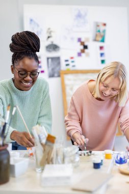 Resim stüdyosunda çalışan genç kadın sanatçılar.