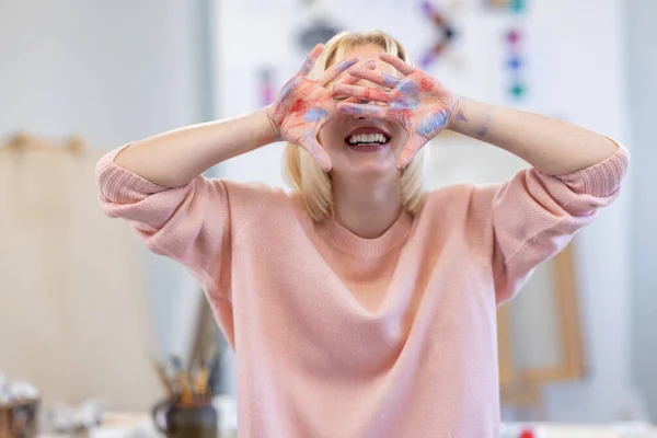 Молода Жінка Художній Студії Посміхається Прикриваючи Обличчя Схрещеними Руками — стокове фото
