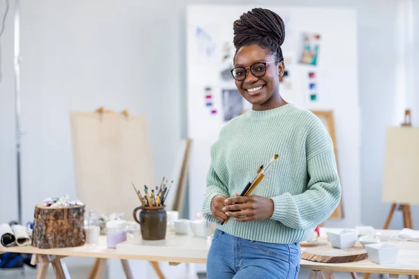 Jonge Vrouwelijke Afrikaanse Kunstenaar Werkt Haar Atelier Poseert Voor Camera Rechtenvrije Stockfoto's