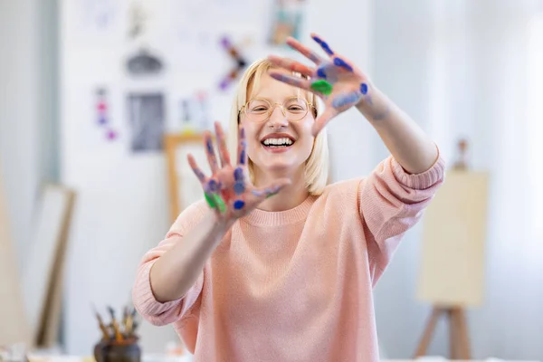 アートスタジオの若い女性が笑顔で 幸せな顔で手と指でフレームを作る ロイヤリティフリーのストック写真
