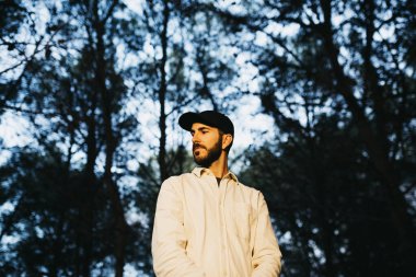 Kırsalda siyah şapkalı genç bir sakallı adamın portresi.