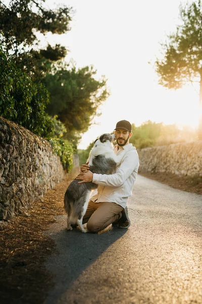 Retrato Jovem Barbudo Usando Boné Preto Abraçando Seu Cachorro Uma — Fotografia de Stock