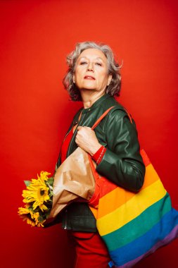 Kırmızı elbiseli son sınıf öğrencisi, kırmızı arka planda.