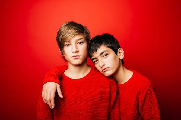 Two Pre Adolescent Boys Wearing Red Sweater Embracing Red Background — Stock Photo, Image