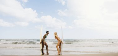 Deniz kenarında sörf tahtası olan iki neşeli genç kadının portresi. İki sörfçü kadın sörfçü..