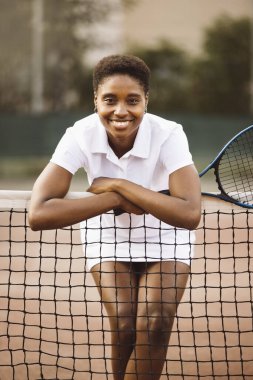 Tenis kortunda tenis kıyafetleri ve raketle oyun oynamaya hazır güzel bir kadının portresi..