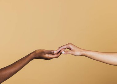 Kahverengi arka planda iki kadının elini birbirine yaklaştırın. İki Afrikalı Amerikalı kadının elleri..