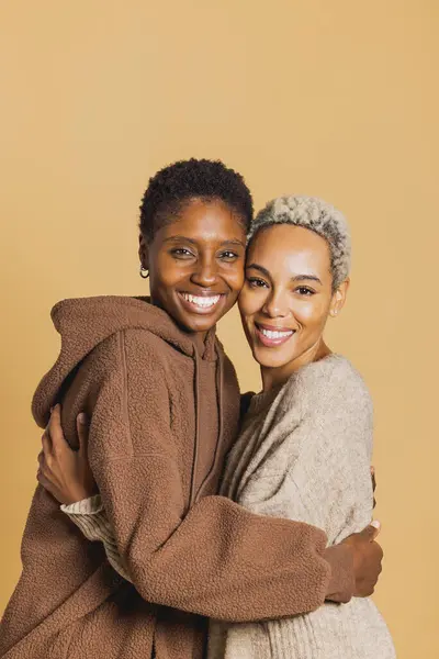 Porträtt Två Unga Afrikanska Amerikanska Kvinnor Omfamna Brun Bakgrund Unga Royaltyfria Stockbilder