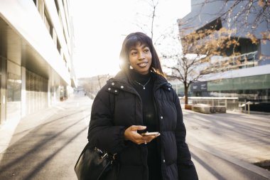 Siyah elbiseli güzel bir kadın büyük bir şehrin sokaklarında yürüyor..