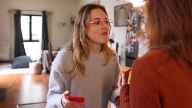 Neşeli, genç, eşcinsel bir çift, mutfaklarının konforlu ortamında kahvaltı ederken öpüşüp, şakalaşıyor..