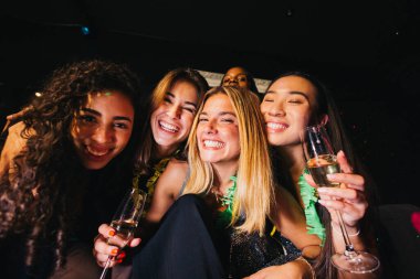 A group of joyful friends enjoying a night out, celebrating at a party with glasses of champagne. They are smiling and embracing, capturing a moment of happiness and friendship. clipart