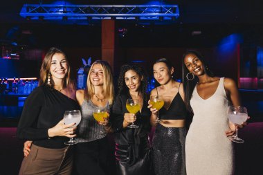 İçki içen kadınların grup portresi, moda bir barda eğlenceli bir gece geçirmek..