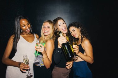 Canlı bir partide şampanyayla kutlama yapan dört arkadaş grubu. Birlikte gülüyor ve keyifli bir akşam geçiriyorlar, mutluluğu ve arkadaşlığı somutlaştırıyorlar..